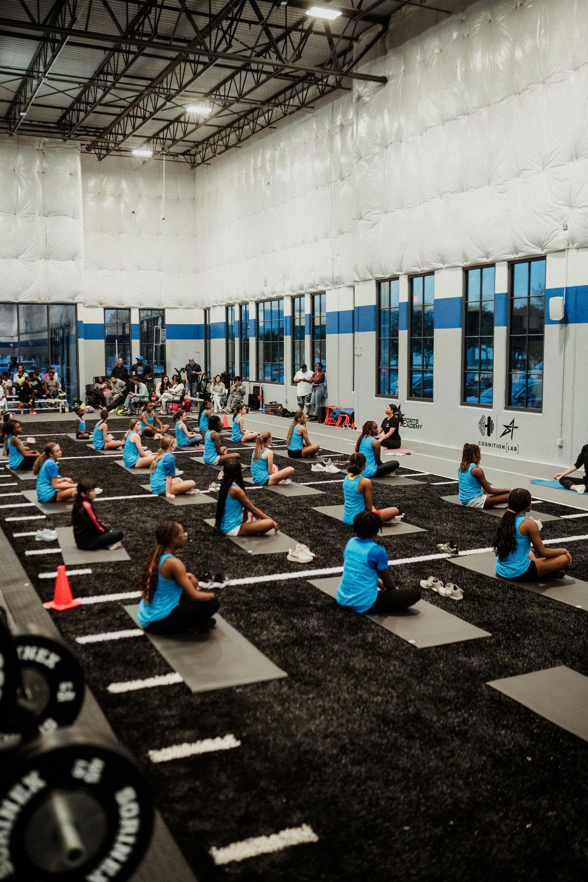 Young athletes and a coach during a group session in a Sports Academy training hall